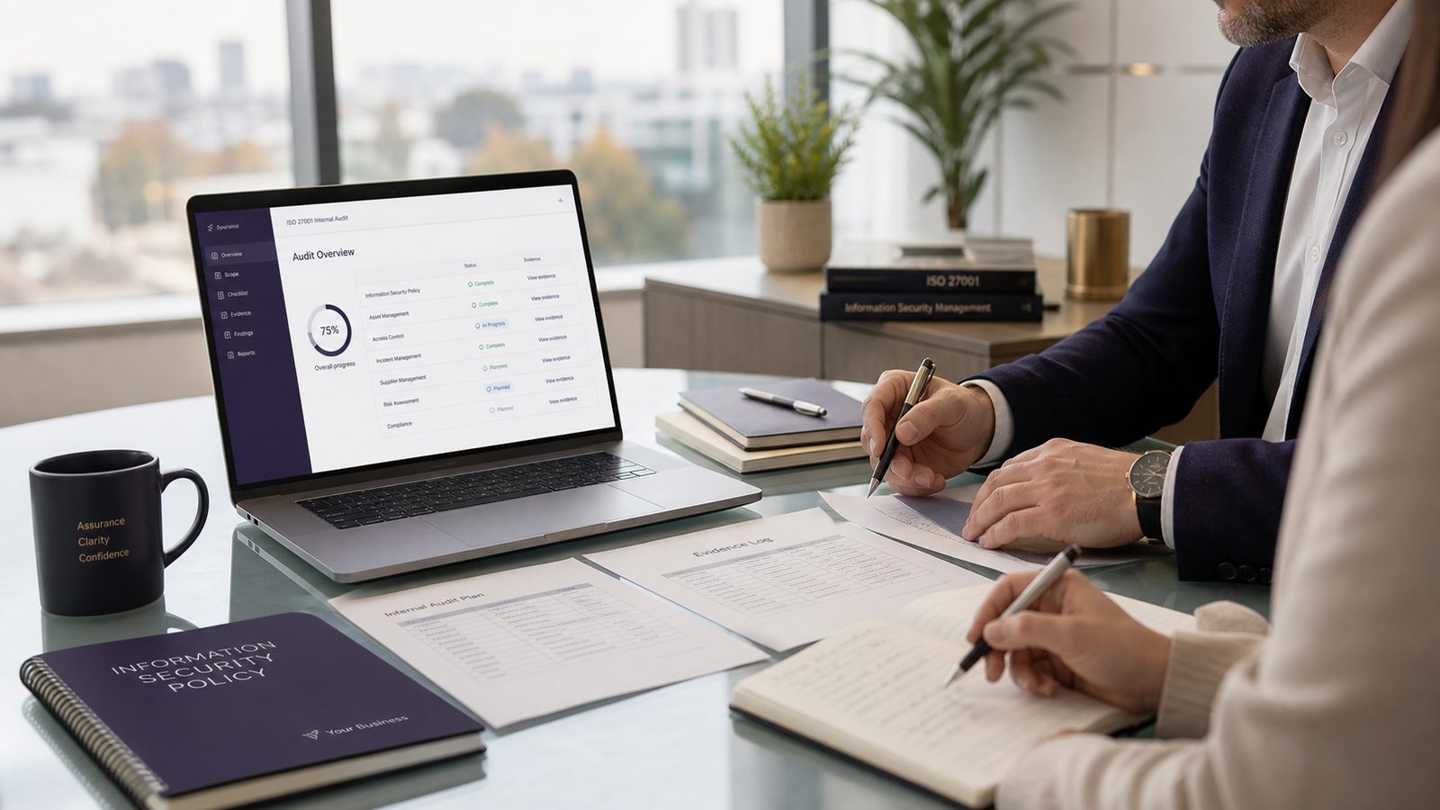 Professionals reviewing internal audit evidence for an ISO 27001 ISMS in a clean office setting
